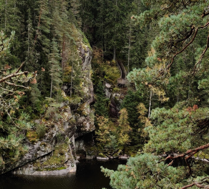 Vy mot utsiktsplattform på en brant vid en sjö.Foto.