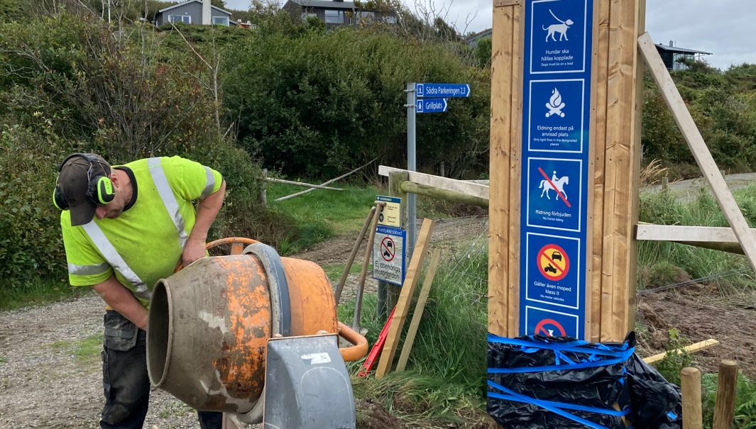 Person stor och gjuter ett skyltställ. Fotot.