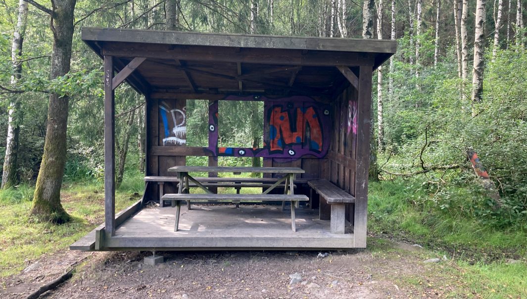 Vindskydd som vandaliserats bl.a. med klotter. Foto.