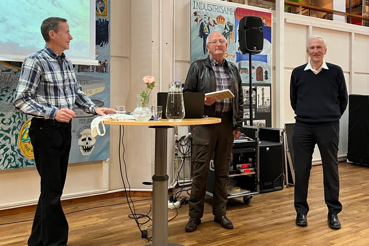 Prisutdelning, ols står i mitten mellan två personer. Foto.