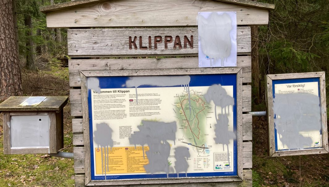 Skyltar och en låda med foldrar som täckts med grå sprayfärg. Foto.