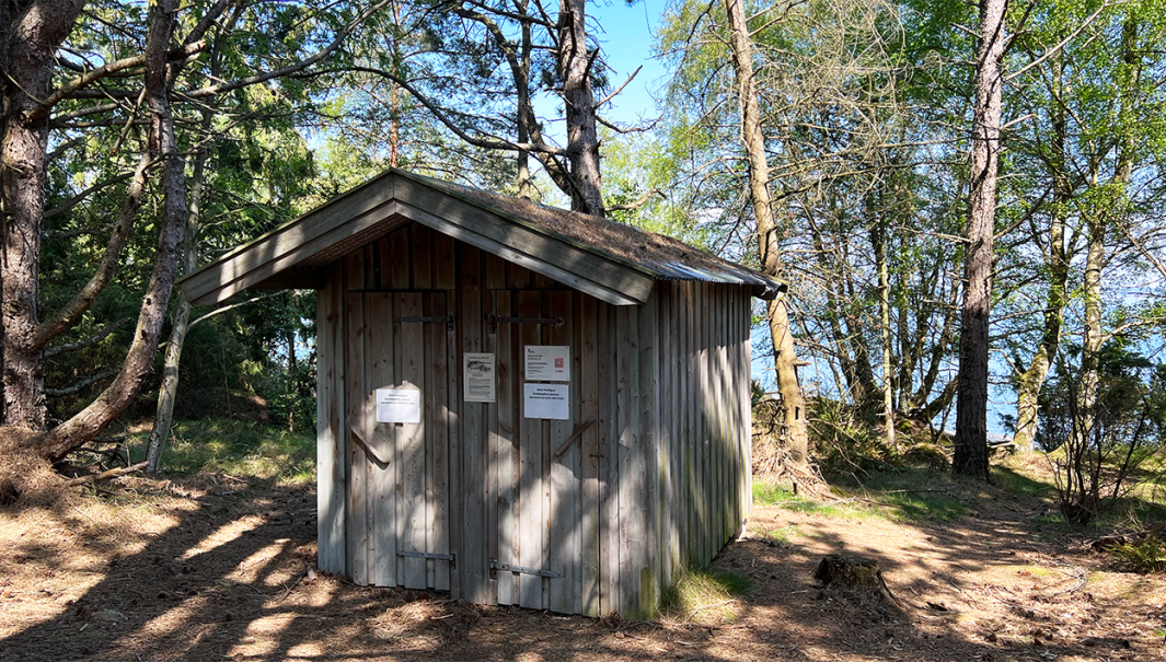 Fotografi på en skärgårdstoalett med två dörrar.