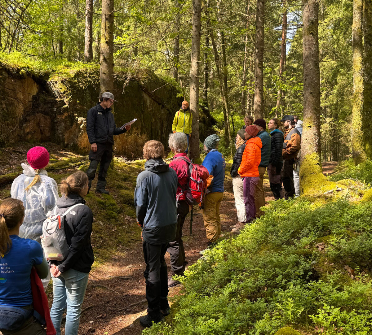 En av Västkuststiftelsens naturvårdare står framför en grupp med ideella. Foto.
