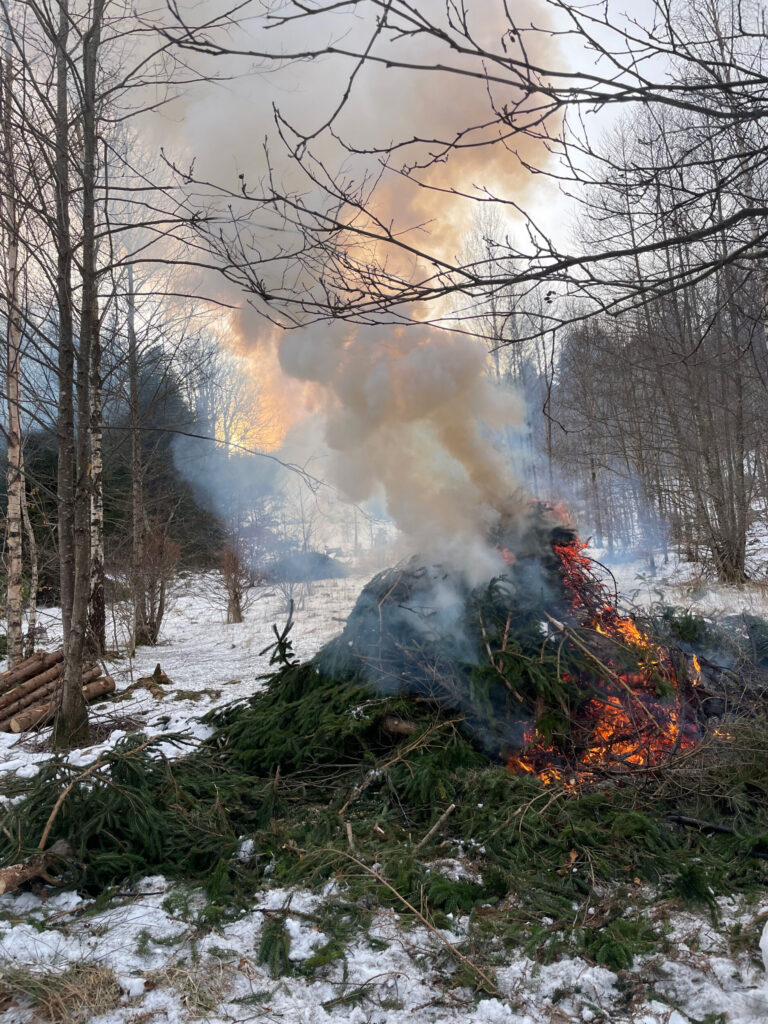 En brinnande granrishög. Foto.