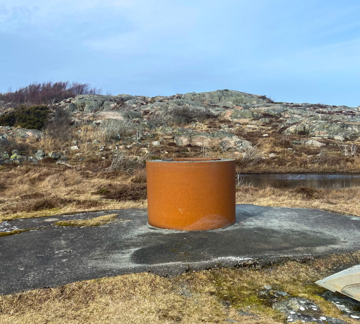 Eldstad i metall bland klippor. Foto.