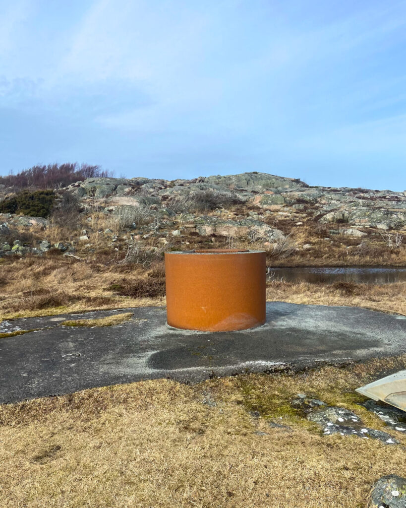 Eldstad i metall bland klippor. Foto.